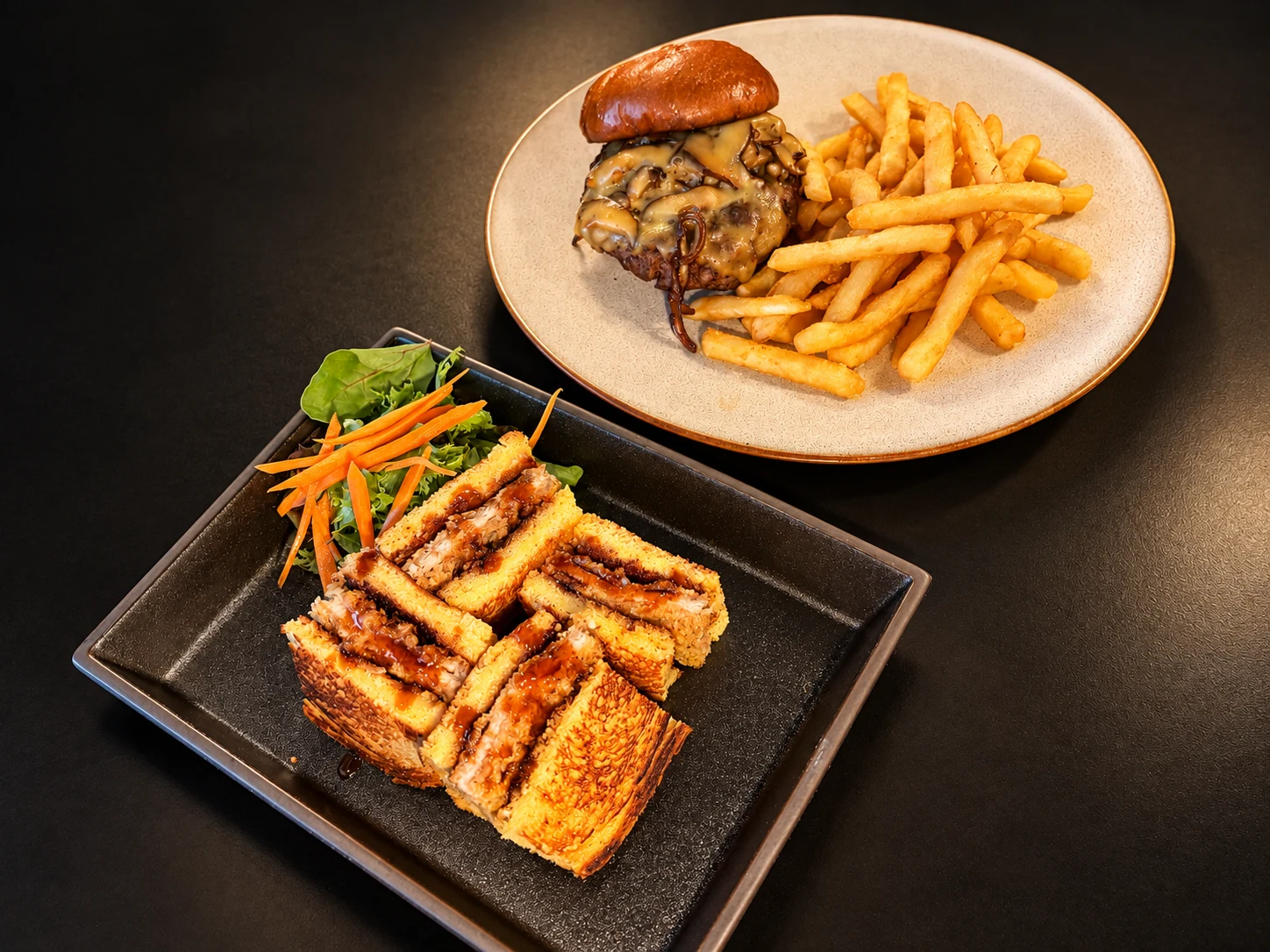 Wagyu Burger with fries alongside Katsu Sando with mixed greens