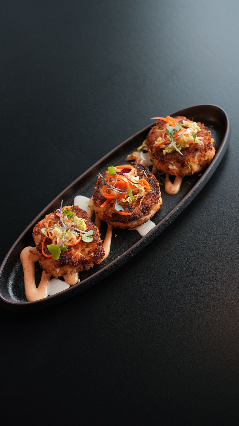 Crab cakes with two-sauce swirl and micro-greens