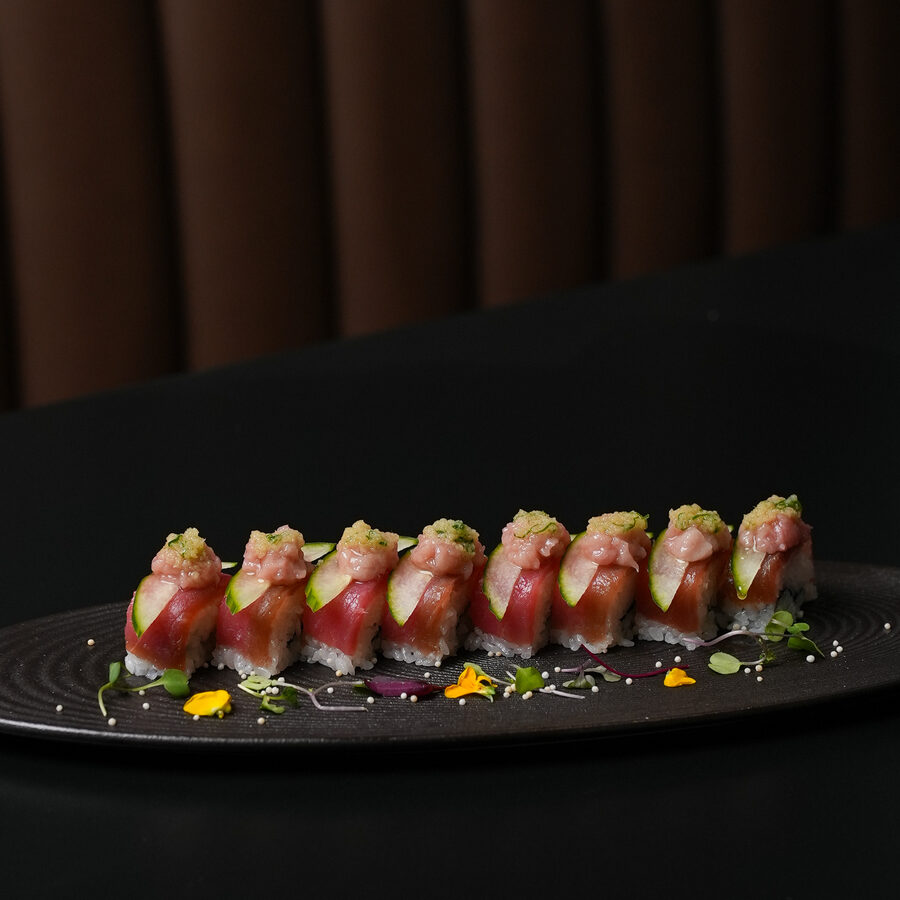 A flight of nigiri on a dark board