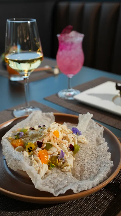 Crab salad with citrus, avocado, and edible flowers in a crisp shell