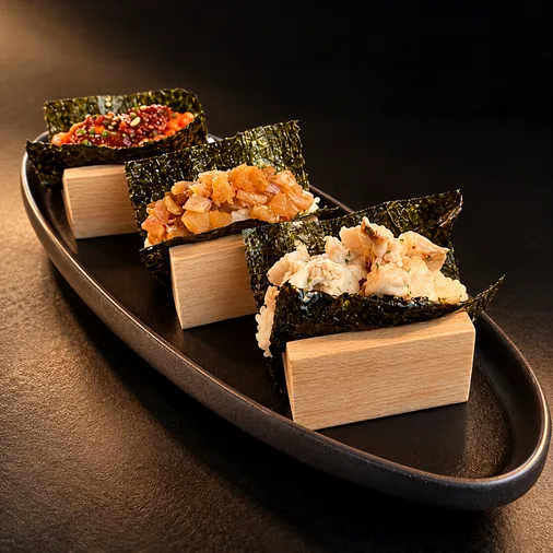 Three nori hand maki served on a black platter